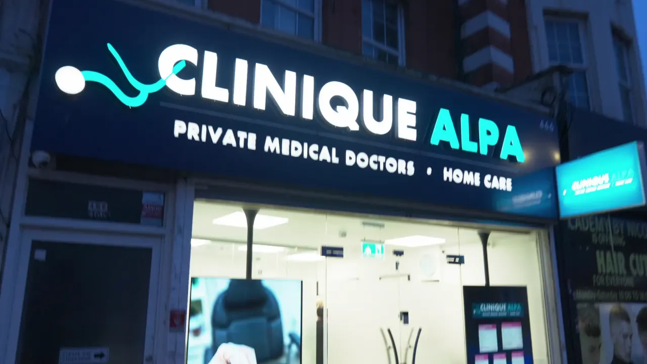 The illuminated Clinique Alpa clinic front on Green Lanes, Palmers Green, at dusk