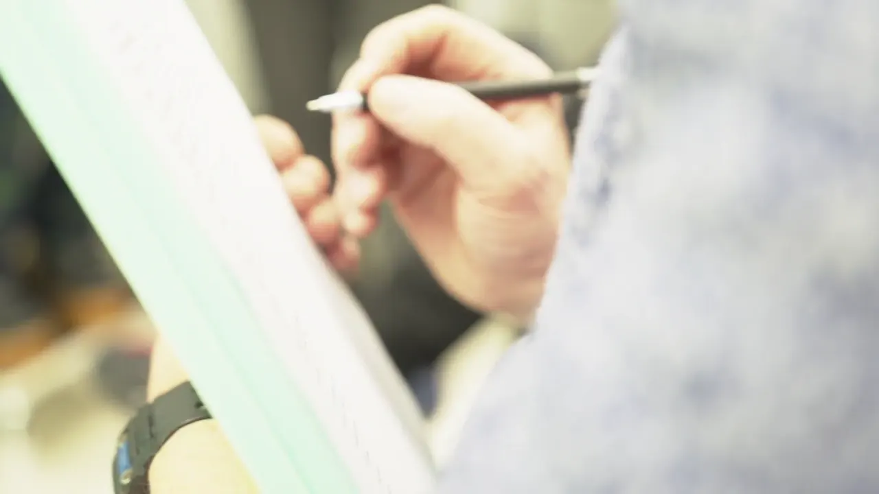 A clinician writing notes on a clipboard during a consultation